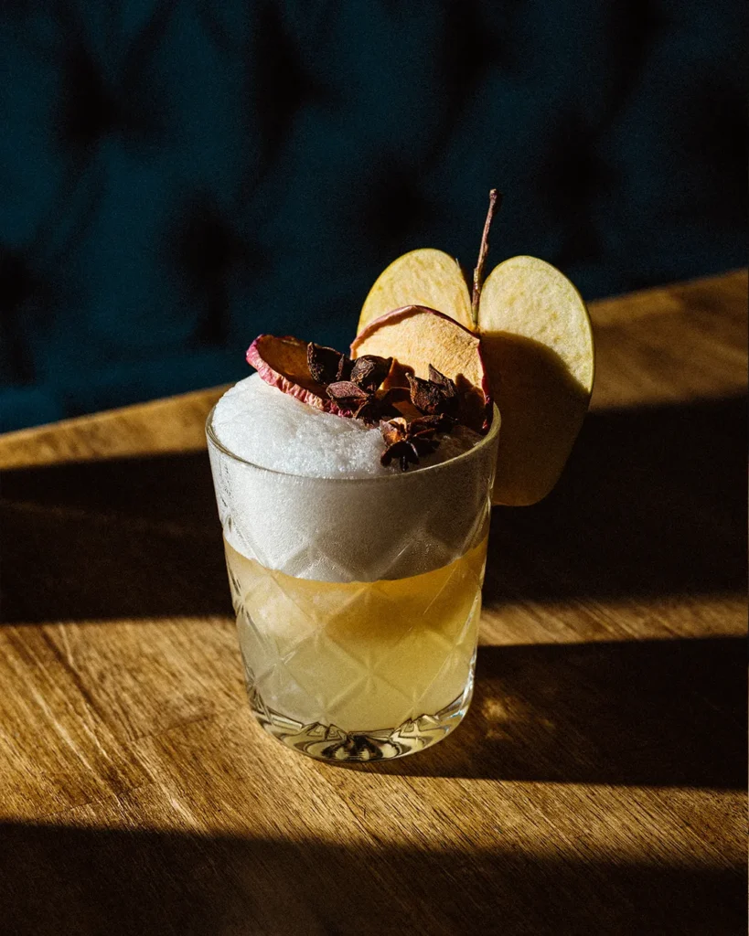 Creamy drink served in a glass on a wooden table, low-light lounge background