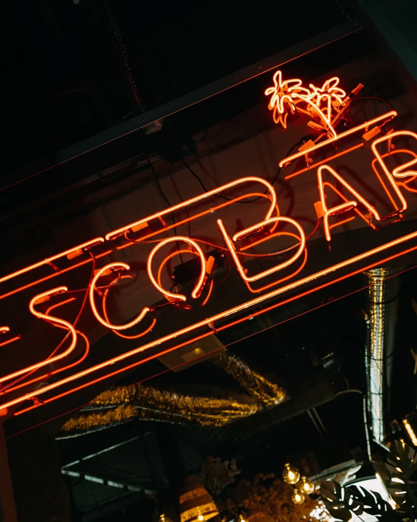 Bright Escobar sign glowing in a dark interior, strong brand identity shot