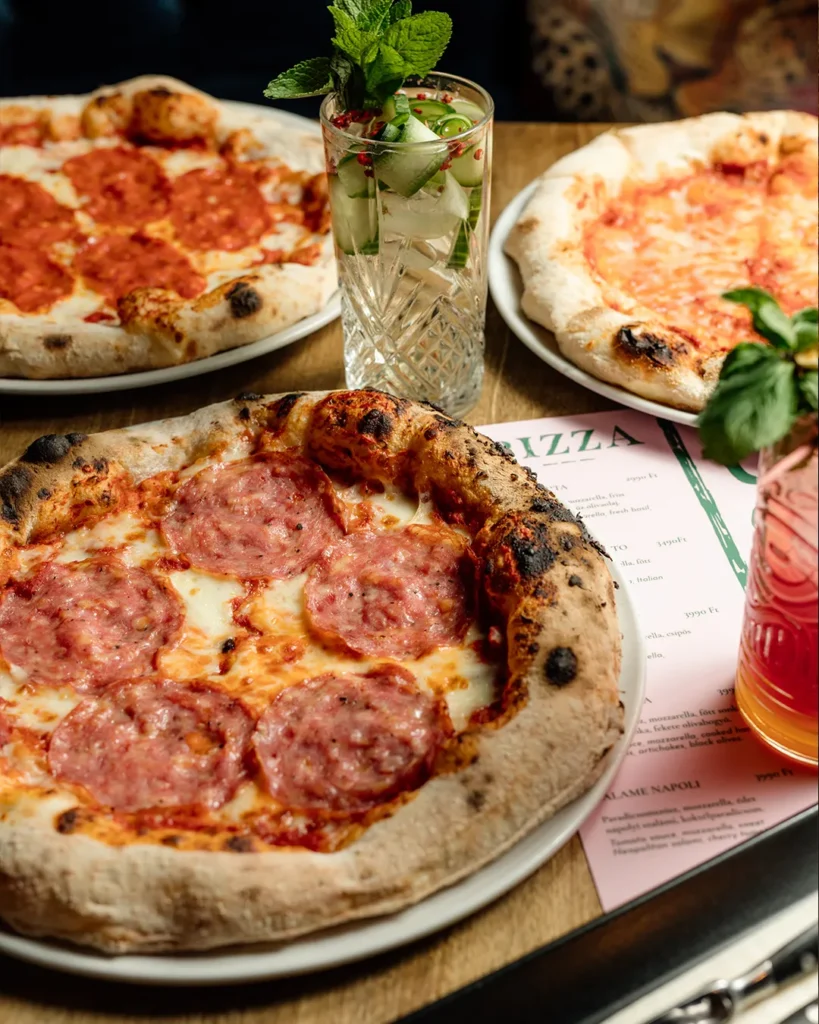 Pizza photographed close-up with toppings visible, warm indoor lighting