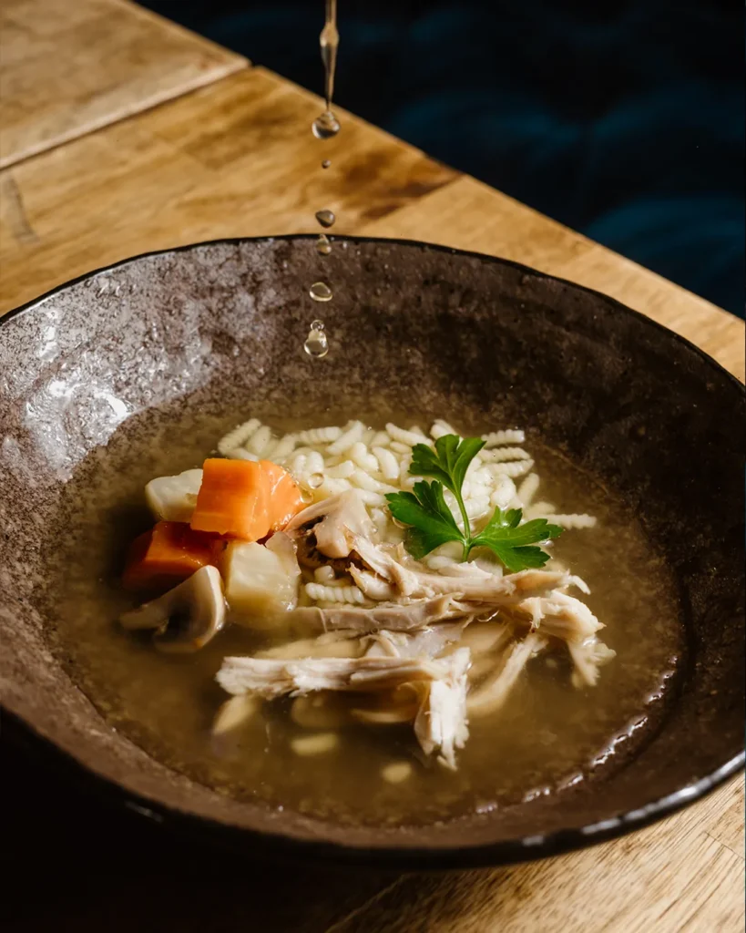 Close-up of a sharing dish with garnish in a rustic bowl, cosy table setting