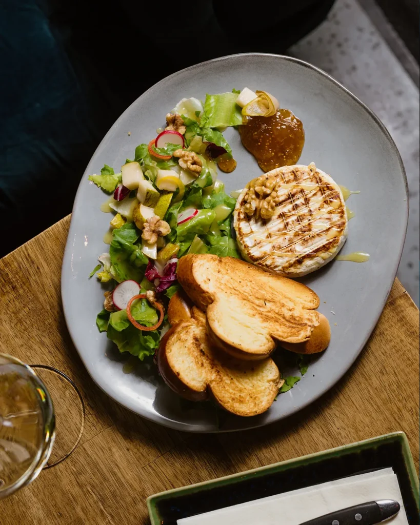 Plated small dish with crisp textures and garnish, photographed on a neutral table
