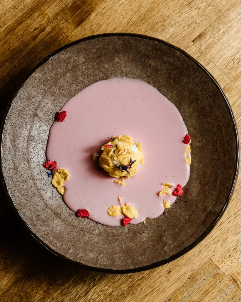 Artistic plated bite with sauce accents on a wide plate, photographed from above